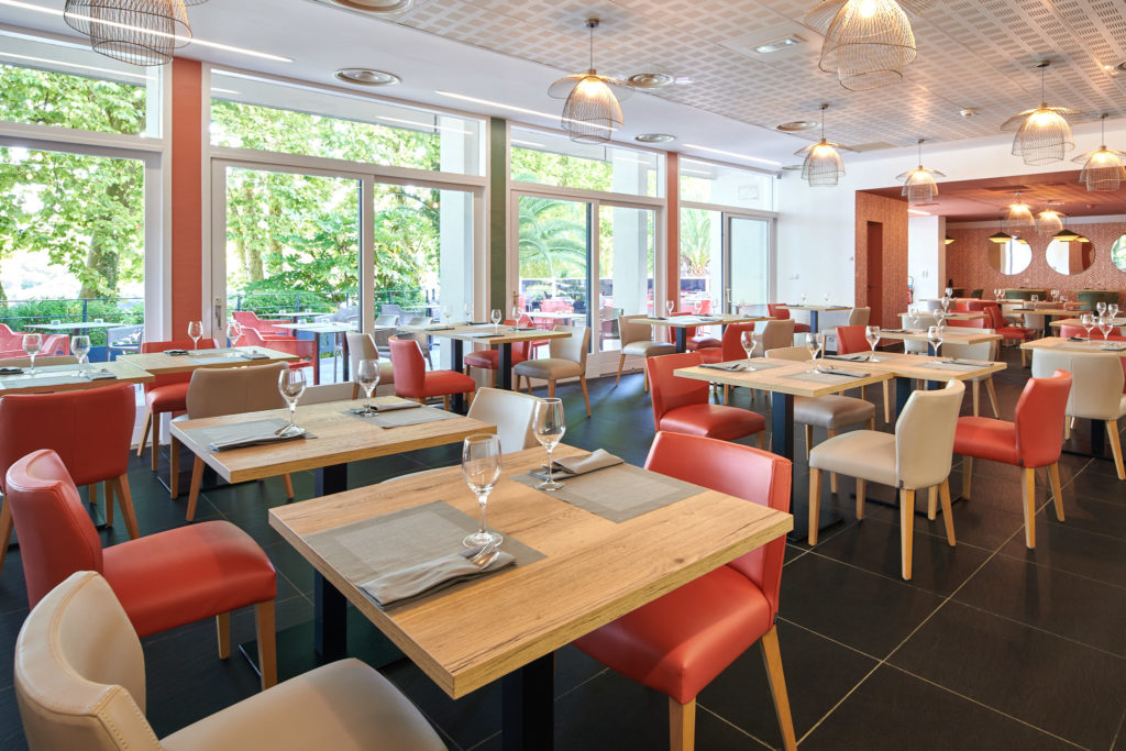 Salle de restaurant avec une décoration terracota et touches de vert à Bayonne