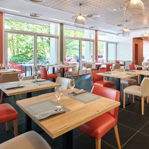 Salle de restaurant avec une décoration terracota et touches de vert à Bayonne